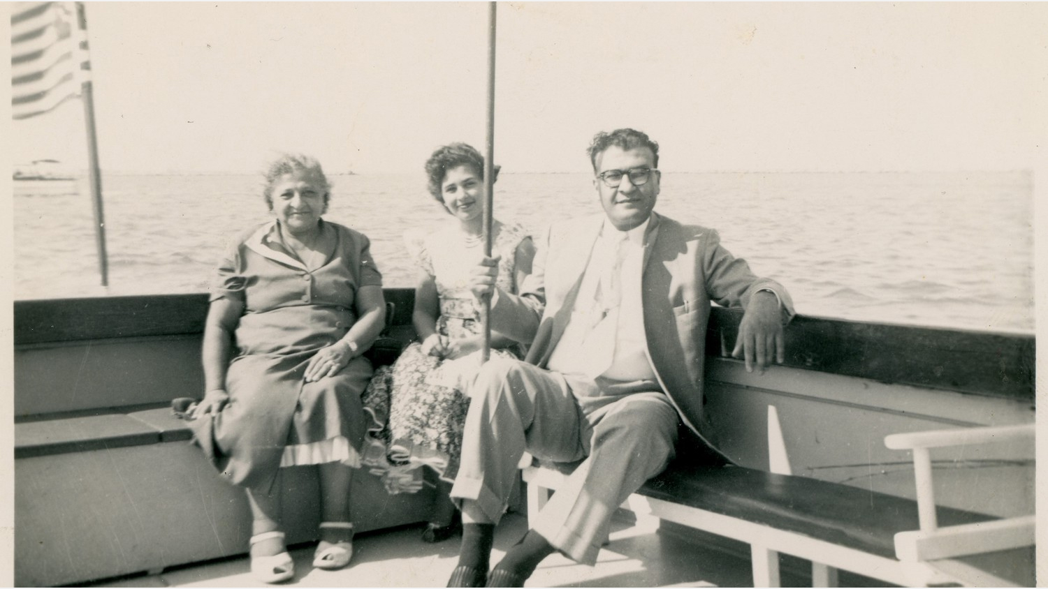 Three people sitting on bench on boat